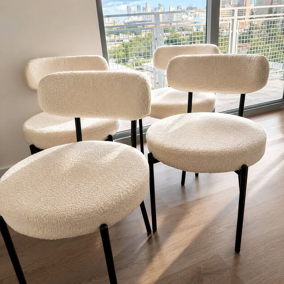 Mila Bouclé Chair mid-century dining chairs with curved padded back by a window