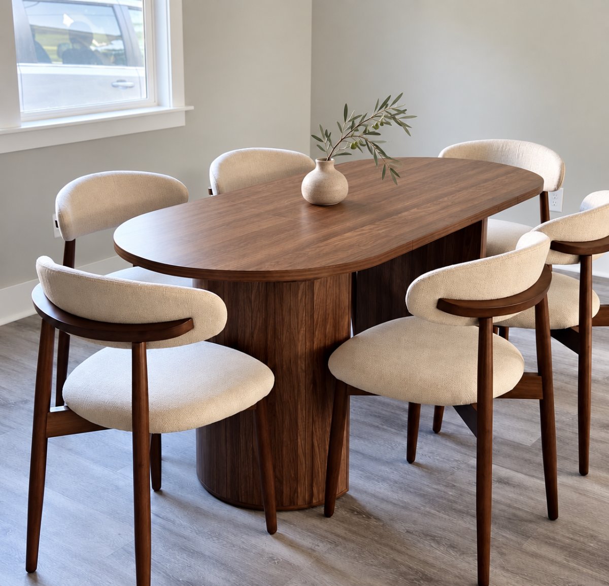 Vera Oval — walnut oval table with fluted pedestal and six cream bouclé chairs in a dining room